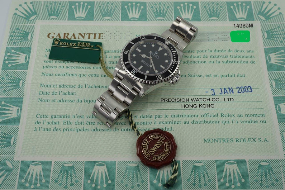 A fine preowned Rolex Submariner non-date reference 14060M in stainless steel originally sold in Hong Kong with papers dated Jan. 2003 and tags, crafted circa 2003. Classic and enduring 40 mm case for casual wear with black bezel, black dial and large lume white round and baton hour markers, and white lume sword-shaped hands. 13 mm silhouette with flip lock steel clasp for secured and comfort fit.

Light wear, small nick located bottom right lug.
Original dial, hands, and crown.
Case measures 40 x 47 mm, 13 mm thick.  
Rolex cal. 3130, highly jeweled automatic winding.
Sapphire crystal.
Serial# Y2135xxx
Rolex flip lock steel bracelet fits 7 3/4 inches.
20 mm between lugs.
Modeled on size 7 3/4 inch wrist.