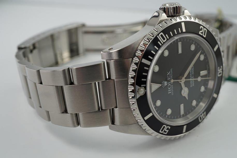 A fine preowned Rolex Submariner non-date reference 14060M in stainless steel originally sold in Hong Kong with papers dated Jan. 2003 and tags, crafted circa 2003. Classic and enduring 40 mm case for casual wear with black bezel, black dial and large lume white round and baton hour markers, and white lume sword-shaped hands. 13 mm silhouette with flip lock steel clasp for secured and comfort fit.

Light wear, small nick located bottom right lug.
Original dial, hands, and crown.
Case measures 40 x 47 mm, 13 mm thick.  
Rolex cal. 3130, highly jeweled automatic winding.
Sapphire crystal.
Serial# Y2135xxx
Rolex flip lock steel bracelet fits 7 3/4 inches.
20 mm between lugs.
Modeled on size 7 3/4 inch wrist.