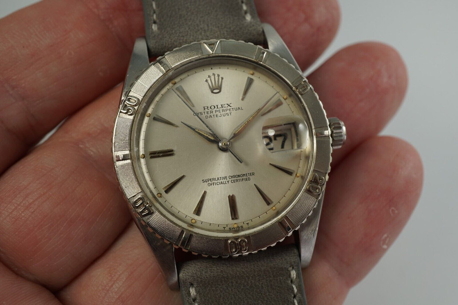 A nice vintage Rolex Datejust 1625 Turn-O-Graph in stainless steel, crafted circa 1964. 36 mm steel case housing bidirectional gold engine-turned finish bezel, lume plot silver dial, silver applied dauphine markers and pointy hour markers, and date aperture. Beautiful patina with original finish, an excellent timeless addition to a vintage collection.

Original silvered dial, hands and crown.
The calendar wheel may have been previously replaced.
Case measures 36 x 44 mm, 12 mm thick.  
Rolex cal. 1570, 26 jewel automatic winding.
Rolex acrylic crystal.
Serial# 1064xxx 
Date coded 111.64.
New premium non-Rolex grey leather strap. 
20 mm between lugs.
Modeled on size 7 3/4 and 6 inch wrist.