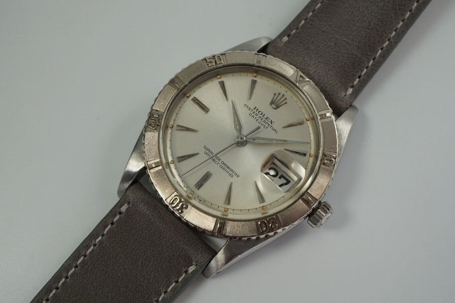 A nice vintage Rolex Datejust 1625 Turn-O-Graph in stainless steel, crafted circa 1964. 36 mm steel case housing bidirectional gold engine-turned finish bezel, lume plot silver dial, silver applied dauphine markers and pointy hour markers, and date aperture. Beautiful patina with original finish, an excellent timeless addition to a vintage collection.

Original silvered dial, hands and crown.
The calendar wheel may have been previously replaced.
Case measures 36 x 44 mm, 12 mm thick.  
Rolex cal. 1570, 26 jewel automatic winding.
Rolex acrylic crystal.
Serial# 1064xxx 
Date coded 111.64.
New premium non-Rolex grey leather strap. 
20 mm between lugs.
Modeled on size 7 3/4 and 6 inch wrist.