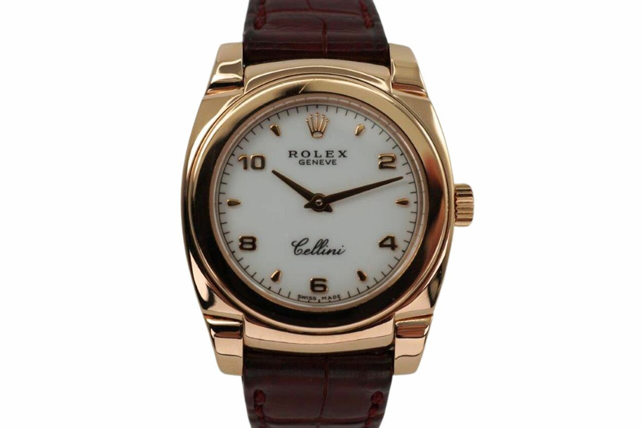 A fine vintage Rolex Cellini Cestello reference 5310 in 18k rose gold, crafted circa 1999. Dainty from its polished cushion-shaped 26mm case and slim 6mm silhouette with flexible lugs, smooth bezel housing a white dial, small rose gold Arabic/ tear drop hour markers, and sword-shaped hands. Paired with burgundy crocodile strap complimenting the rose gold. 

Minimal scratches.
Original dial, hands and crown. 
Case measures 26 x 32mm, 6mm thick.
Rolex cal. 1602, 20 jewels mechanical winding.
Sapphire crystal.
Serial# A8412xx
Rolex burgundy crocodile strap (80% condition approximation).
Rolex 18k rose gold buckle.
Modeled on a 6 inch wrist.