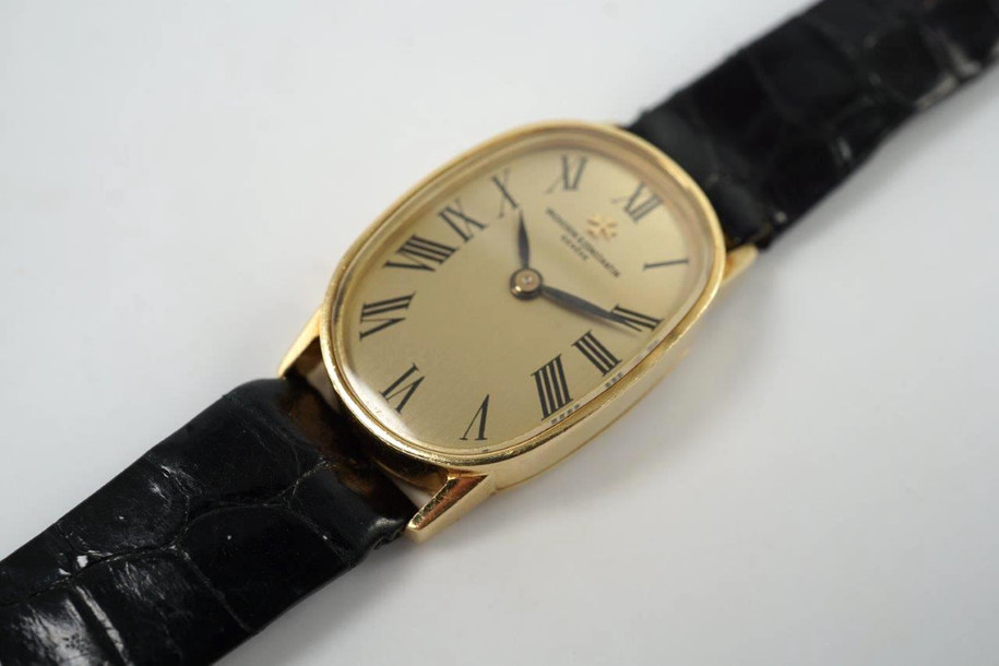 A wonderful Vacheron Constantin ladies watch reference 18220 in 18k yellow gold, crafted during the 1950s. Strong oval 18mm case with 12mm silhouette housing a gold colored dial, black Roman numeral hour markers and blackened-steeled feuille hands. This dainty accessory can be worn for a variety of occasions, a classic with the gold frame and black crocodile strap. 

Minimal scratches.
Original dial, hands and crown. 
Case measures 18 x 28mm, 12mm thick.
V+C cal. 1430, 18 jewels manual winding.
Sapphire crystal.
Serial# 5201xx Movement# 674457
V+C black crocodile strap (85% condition approximation).
V+C 18k gold buckle.
Modeled on a 6 inch wrist.