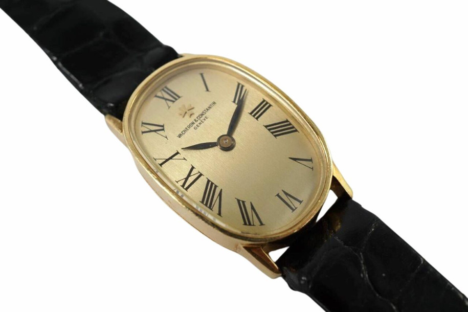 A wonderful Vacheron Constantin ladies watch reference 18220 in 18k yellow gold, crafted during the 1950s. Strong oval 18mm case with 12mm silhouette housing a gold colored dial, black Roman numeral hour markers and blackened-steeled feuille hands. This dainty accessory can be worn for a variety of occasions, a classic with the gold frame and black crocodile strap. 

Minimal scratches.
Original dial, hands and crown. 
Case measures 18 x 28mm, 12mm thick.
V+C cal. 1430, 18 jewels manual winding.
Sapphire crystal.
Serial# 5201xx Movement# 674457
V+C black crocodile strap (85% condition approximation).
V+C 18k gold buckle.
Modeled on a 6 inch wrist.