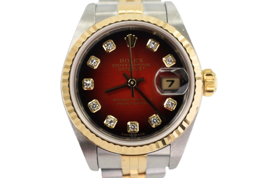 A fine preowned Rolex Datejust reference 79173 in stainless steel and 18k yellow gold, crafted circa 2001. This special 26mm watch houses a factory red vignette dial with diamond hour markers and gold applied hands, and date aperture. The vivid dial paired with the fluted gold bezel and two-tone jubilee bracelet create a distinct look on the wrist.