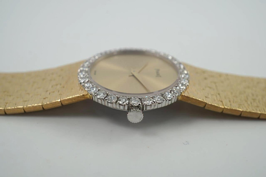 A fine vintage Piaget diamond bracelet watch in 18k yellow gold, crafted during the 1970s. The 25mm round and 5mm silhouette case houses 30 diamonds factory set bezel, approximately 1.20 carats, gold dial and dauphine hands. A beautiful accessory worn elegantly on the wrist for casual or formal wear.

Light scratch on crystal, 7 o’clock position.
Original dial, hands and crown. 
Case measures 25 x 25 mm, 5mm thick.
Piaget cal. 9P, 18 jewels mechanical winding. 
Sapphire crystal.
Serial# 151477 Movement# 6896xx
Piaget bracelet fits 6 1/4 inches or 16 cm approximate, links are removable.
16mm wide bracelet, tapers.
Modeled on a 6 inch wrist.