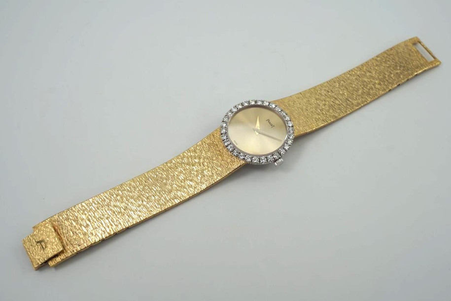 A fine vintage Piaget diamond bracelet watch in 18k yellow gold, crafted during the 1970s. The 25mm round and 5mm silhouette case houses 30 diamonds factory set bezel, approximately 1.20 carats, gold dial and dauphine hands. A beautiful accessory worn elegantly on the wrist for casual or formal wear.

Light scratch on crystal, 7 o’clock position.
Original dial, hands and crown. 
Case measures 25 x 25 mm, 5mm thick.
Piaget cal. 9P, 18 jewels mechanical winding. 
Sapphire crystal.
Serial# 151477 Movement# 6896xx
Piaget bracelet fits 6 1/4 inches or 16 cm approximate, links are removable.
16mm wide bracelet, tapers.
Modeled on a 6 inch wrist.