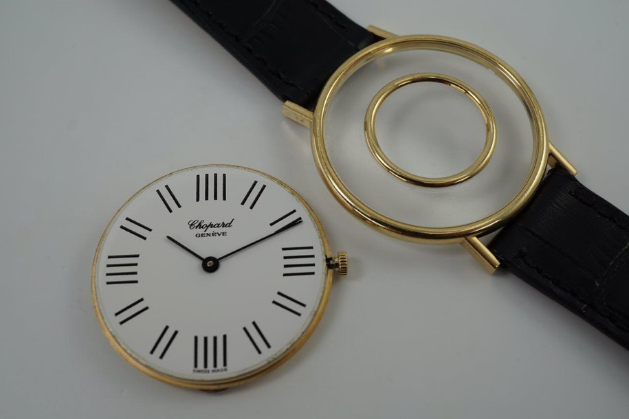 A very cool preowned Chopard watch in 18k yellow gold, crafted during the 1970s. A design that we have yet to come across, with an inner gold bezel surrounded by black hour markers we cannot distinguish what they represent. The 12, 3, 6, and 9 o'clock contain four hash marks while the rest contain two. Classic white dial and black hour markers and hands, yet distinctive from the standard in a 34mm round case and slim 6 mm silhouette would suit a variety of wrists and wardrobes. 

Original dial, hands and L.U.C. crown. 
Case measures 34 x 38 mm, 6mm thick.
Chopard L.U.C. cal. P7001, 17 jewels manual wind.
Sapphire crystal.
Serial# 146442-1048
New non-Chopard black leather strap.
17mm lug width.