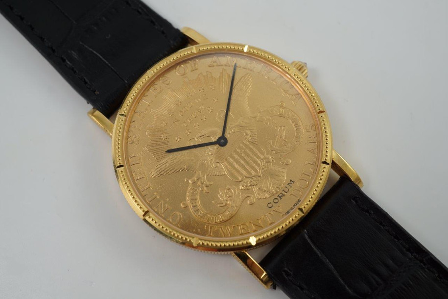 A near mint Corum $20 1900 Liberty US coin watch in 18k yellow gold, crafted during the 1990s. Features classic ridge-edged, beaded minute and notched hour markers on bezel, black-steeled sword-shaped hands and diamond crown. Durable for everyday wear, making a lovely golden statement on the wrist. 

Original dial, hands and diamond crown.
Case measures 35 x 42mm, 4.5mm thick.
High grade Swiss mechanical movement, 18 jewels, 3 adjustments.
Case# 5762xx Movement# 5225xx
Sapphire crystal.
New non-Corum black leather strap.
Fits up to 7 1/5 inches.
Corum 18k tang buckle.
20mm lug width.
Modeled on 6 inch wrist.