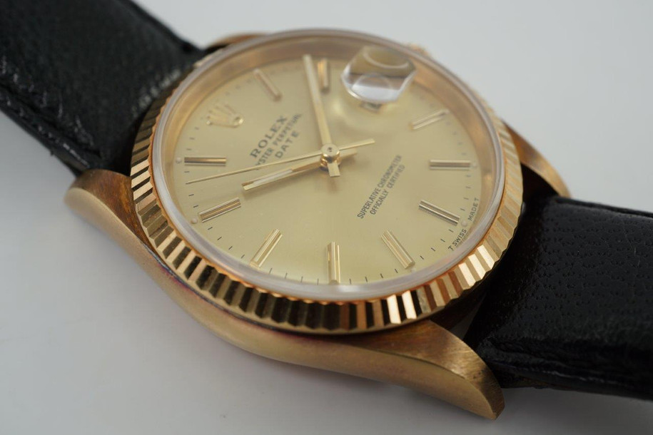 A finely preserved Rolex Date reference 15238 in 18k yellow gold, produced circa 1993. An incredible find of a 20 year award dedication watch, unpolished and turned a lovely patina orange peachy. Featuring 34mm round case with fluted bezel, champagne dial, gold applied beveled hour markers with lume end plots and baton hands with lume in middle, and date aperture. Paired with a Rolex black leather strap and its original gold plated buckle, this handsome time capsule piece would make an excellent addition to a collection.

Dial has small bubbles, patina’d case.
Case back has engraving.
Rolex NYC papers dated May 1993.
Original dial, hands and crown.
Case measures 34 x 43mm, 11.5mm thick.
Sapphire crystal. 
Rolex cal., automatic winding. Quick set date.
Serial# N1994xx
Rolex black leather strap.
Rolex gold plated buckle.
19mm lug width.
Modeled on 6 inch wrist.