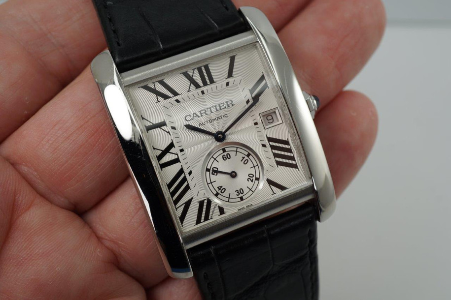 A fine preowned Cartier Tank MC reference W5330003 in stainless steel, crafted circa 2017. Features a bold 34mm rectangular case with 9mm thickness housing a silvered guilloche dial, black Roman numeral hours, inner minute track, date aperture at 3 o’clock and subsidiary seconds dial located 6 o’clock, and blue cabochon octagonal crown. The exhibition case back showcases the beautiful automatic movement, and outfitted with a black crocodile strap with a deployant closure. Accompanied by its box and papers dating 06-2017, US retail is approximation of 6650 USD. 

Scratches throughout. 
Original dial, hands, and gold crown. 
Case measures 34 x 44 mm, 9mm thick.
Sapphire crystal. 
Serial# 3514xxxX
Cartier cal. 1904 P.S., 27 jewels automatic winding.
Black crocodile strap (85% condition approximate).
Cartier steel deployant. 
26mm lug width.
Modeled on 6 inch wrist.