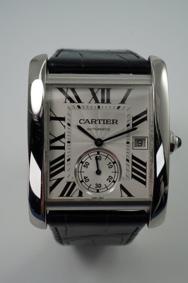 A fine preowned Cartier Tank MC reference W5330003 in stainless steel, crafted circa 2017. Features a bold 34mm rectangular case with 9mm thickness housing a silvered guilloche dial, black Roman numeral hours, inner minute track, date aperture at 3 o’clock and subsidiary seconds dial located 6 o’clock, and blue cabochon octagonal crown. The exhibition case back showcases the beautiful automatic movement, and outfitted with a black crocodile strap with a deployant closure. Accompanied by its box and papers dating 06-2017, US retail is approximation of 6650 USD. 

Scratches throughout. 
Original dial, hands, and gold crown. 
Case measures 34 x 44 mm, 9mm thick.
Sapphire crystal. 
Serial# 3514xxxX
Cartier cal. 1904 P.S., 27 jewels automatic winding.
Black crocodile strap (85% condition approximate).
Cartier steel deployant. 
26mm lug width.
Modeled on 6 inch wrist.