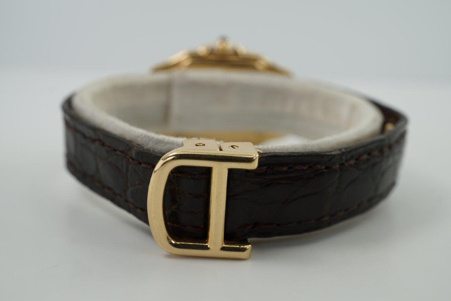 A very nice preowned Cartier Panthere reference 8057929 in 18k yellow gold, crafted circa 1995. A popular and long standing classic in a mini size, measuring 22 mm across and 5 mm thick, featuring a silvered dial, black Roman hour markers with tiny Cartier signature located at 10 o’clock and inner minute track, blued-steel sword-shaped hands and blue cabochon hexagonal crown tucked into its crown protector. Paired with its original brown crocodile strap and its 18k deployant buckle for easy fastening. Wears well for casual occasions.