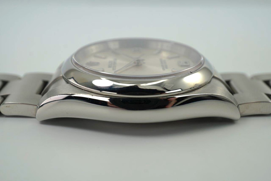 A preowned Rolex Oyster Perpetual reference 116000 in stainless steel, crafted circa 2011. The 36 mm case features a smooth bezel and silver sunburst dial with luminescent baton and Arabic numeral hour markers located 3, 6, and 9 o’clock, silver baton hands with lume, and outer black minute track. Houses an automatic movement, steel Oyster bracelet with deployant clasp, and is accompanied by its card dated March 23, 2011 from Milano. A nice minimal accessory for both men and women for casual occasions.