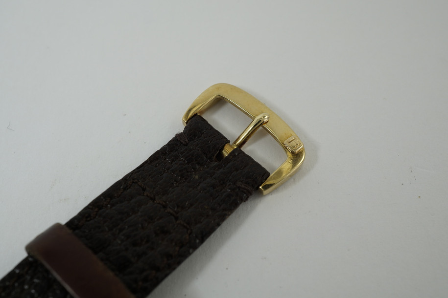 A rare Bulgari Two Time Zone watch in 18k yellow gold, crafted during the 1970s. Featuring an overall two-tone configuration with gold dial and yellow gold applied hands on silver dual time zones with black stick hour markers and double gold crowns to individually set both times. The rectangular case has a slight robust weight and makes a contrast with the dual circular two time creating a harmonious juxtaposition. A neat accessory for the avid traveller, for man or woman.

Light scratches due to age and some usage.
Original dial, hands and crown. 
Case measures 25 x 37mm, 7mm thick.
2 separate movements by Ebel signed Gerald Genta, 17 jewel mechanical winding.
Sapphire crystal.
Serial# G1464-7-17
Bulgari brown exotic strap (90% condition, approximate).
Bulgari 18k gold buckle.
20 mm lug width. 
Modeled on a 6 inch wrist.