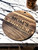 Round Acacia wood cutting board engraved with "Mom's Kitchen: Love Served Here"