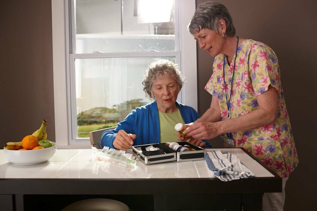 Nurse helping old woman with medicine case