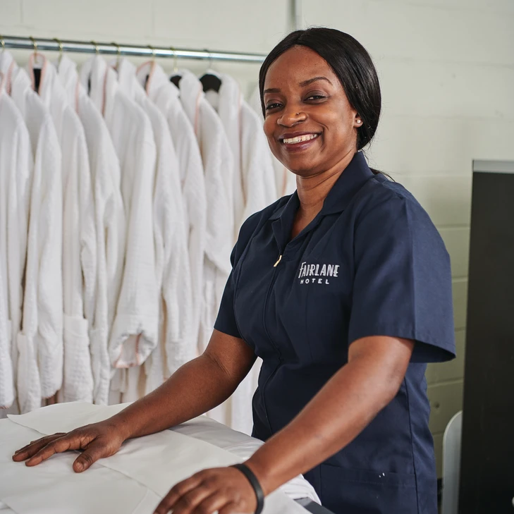 hotel employee wearing Women's Zip Front Smock in navy with logo embroidered on chest
