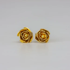 gold earrings which look like roses.