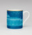Blue mug with white handle against a white background