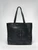 Leather black tote with the words The Frick Collection and its logo on its side and straps standing upright forming a triangle