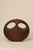 Dark walnut wood handbag with two oval openings forming an owl-like face, photographed closed against a neutral background.