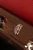 Close-up of the red leather-lined interior of the walnut wood handbag, featuring the Frick Collection monogram in silver.
