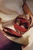 Open walnut wood Moon handbag with a red leather-lined interior, showing space for personal belongings, and featuring the Frick Collection monogram.