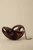 Walnut wood handbag shown open with its distinctive oval cutouts, red leather interior, and silver-tone wristlet chain.