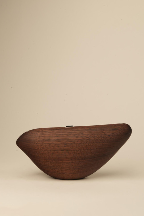 Closed dark walnut wood Bird handbag with a sleek, elongated form and gently curved silhouette.