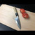 Tsukiji Aritsugu Deba Knife 210mm Blue Steel #2 on Wooden Cutting Board with Sliced Tomatoes