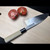 Aritsugu Usu Deba Knife 150mm in White Steel #2 with sliced tomatoes on a wooden cutting board