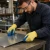 Worker wearing A3 cut-resistant gloves while handling sheet metal in a manufacturing workshop environment