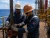 Oil rig workers wearing fiberglass hard hats, safety glasses, gloves, and coveralls while working together on offshore drilling equipment.