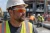 Construction worker wearing orange mirror lens safety glasses, hard hat, and high-visibility vest