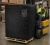 Forklift operator moving a pallet with a black quilted insulated pallet cover in a warehouse storage facility