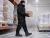 Cold storage warehouse worker wearing black insulated work boots and cold-weather PPE while carrying frozen inventory in a freezer facility.
