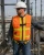 Worker wearing a hi-vis orange safety vest with integrated fall protection harness