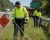 Worker wearing an ANSI Class 3 hi-vis long sleeve safety shirt while mowing along a roadside highway work zone