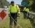 Worker wearing an ANSI Class 3 hi-vis long sleeve safety shirt while mowing along a roadside highway work zone