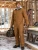 Worker wearing an insulated brown coverall at a snowy construction site for cold-weather jobsite protection