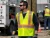 Utility worker wearing a high-visibility ANSI Class 2 reflective 5-point breakaway safety vest on an outdoor jobsite