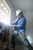 Worker wearing cowboy style full brim hard hat safety helmet on construction site providing ANSI certified head protection