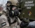 Hazmat response worker wearing an Avon C50-style respirator with AVON CBRNCF50 CBRN filters while inspecting a 40mm NATO filter cartridge