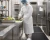 Food prep worker wearing a disposable white apron, mask, and hair cover in a commercial kitchen