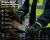 Worker wearing PU waterproof mechanical gloves using a ratchet tool in wet cold-weather construction conditions.