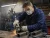 Worker wearing a disposable respirator while grinding metal in an industrial shop