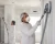 Drywall workers wearing N95 respirators while sanding walls during interior renovation