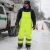 Worker wearing cold weather ANSI Class E quilted safety bibs during winter roadside utility work