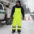 Worker wearing cold weather ANSI Class E quilted safety bibs during winter roadside utility work