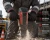 Worker wearing anti-vibration work gloves while operating a jackhammer on a dusty construction jobsite